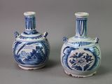 pair of blue and white vases sitting on top of a gray surface