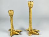 a pair of gold candlesticks on a white background