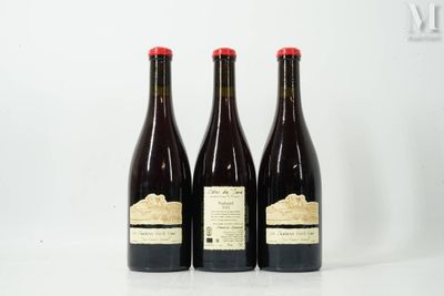 trois bouteilles de vin posées sur une table blanche