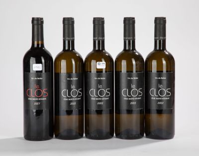 quatre bouteilles de vin sont alignées sur une surface blanche