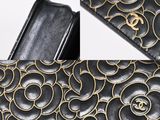 a close up of a black purse with a gold flower design