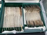 a green case with silverware in it on a table