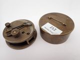 une vieille horloge avec un boîtier en métal et un cadran en métal