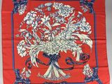 une image représentant une écharpe rouge ornée d'un bouquet de fleurs