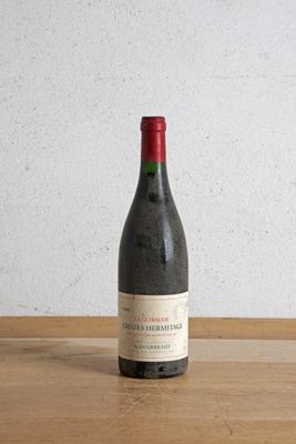 une bouteille de vin posée sur une table devant un mur
