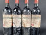 three bottles of red wine sitting next to each other on a table