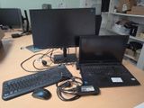 a desk with two computers and a keyboard on it