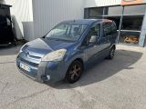 La petite camionnette bleue est garée devant un immeuble.