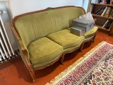 a green couch with a box on it in a living room