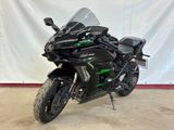 a black motorcycle parked in front of a white backdrop
