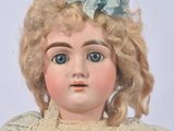 a close up of a doll with blonde hair and blue eyes