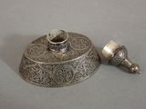 a small silver object on a table next to a smaller silver object
