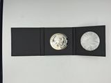 an image of a silver coin sitting on top of a black folder