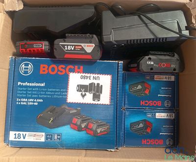 Des boîtes d'outils électriques Bosch sont posées sur un carton.