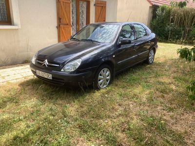 une photo d'une voiture noire garée dans une cour