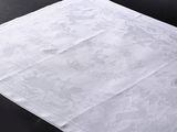 une image représentant un mouchoir blanc posé sur une table noire