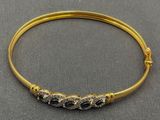 Gros plan sur un bracelet en or orné de pierres bleues