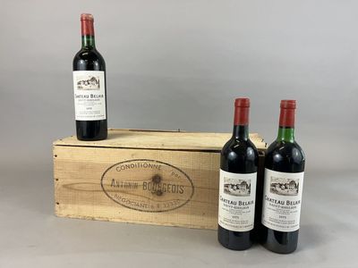 three bottles of red wine in a wooden box on a table