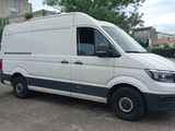 a white van parked in a parking lot next to a silver car
