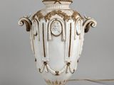 un vase blanc orné d'une horloge, posé sur une table