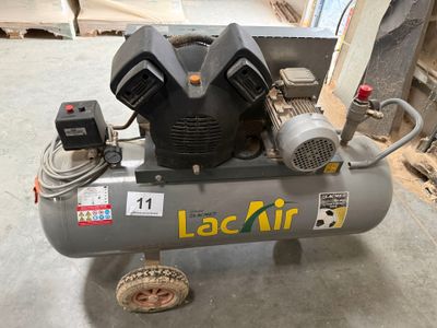 un petit compresseur d'air posé sur un chariot dans le garage