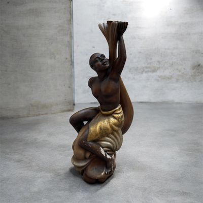 statue d'une femme tenant un panier sur la tête dans une pièce
