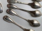 six silver spoons are lined up in a row on a table