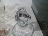 un vase en verre posé sur une table à côté d'un beignet