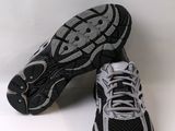 pair of black and silver running shoes on a white surface
