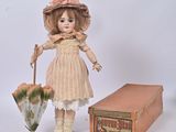 a doll that is standing next to a box and an umbrella