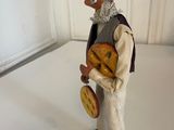 a figurine of a man with a hat and a bag of bread