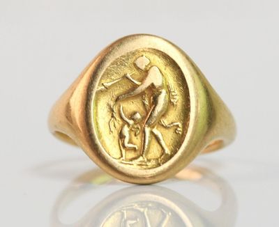 une image représentant une bague en or sur laquelle figurent un homme et un chien