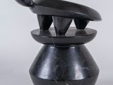 un vase noir surmonté d'un serpent