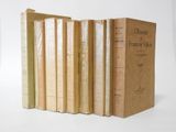 several books are lined up in a row on a white surface