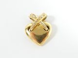 a close up of a heart shaped brooch with a cross on it