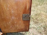 une armoire en bois sur laquelle est accrochée une pancarte, posée dans l'herbe