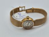 une image d'une montre-bracelet en or avec des chiffres romains