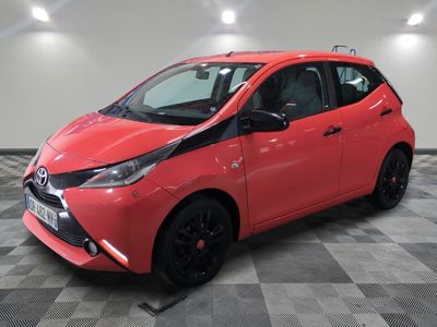 a red toyota ay parked on a checkered floor