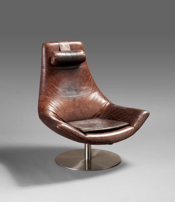 a brown leather chair with a metal base and foot rest