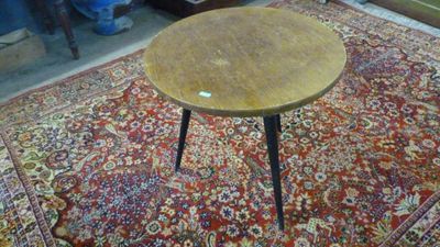 une petite table en bois posée sur un tapis dans une pièce