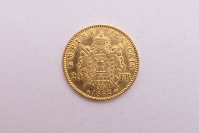 gros plan d'une pièce d'or sur une surface blanche