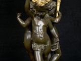 an image of a bronze statue of a boy holding a candelabra