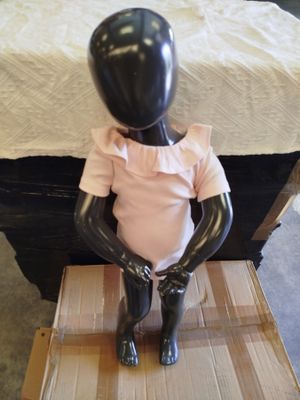 a black mannequin sitting on top of a box