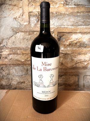 a bottle of wine sitting on a table in front of a brick wall
