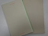 two pages of paper with red writing on them sitting on a table