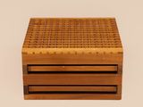 a close up of a wooden box on a white surface