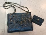 a black chanel bag and wallet on a tiled floor