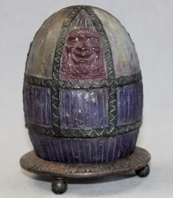 a purple and black egg with a purple face on it
