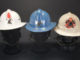 three firemen ' s hats are lined up on a mannequin head