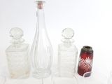 des bouteilles et des verres posés sur une table, avec une canette de soda à l'arrière-plan